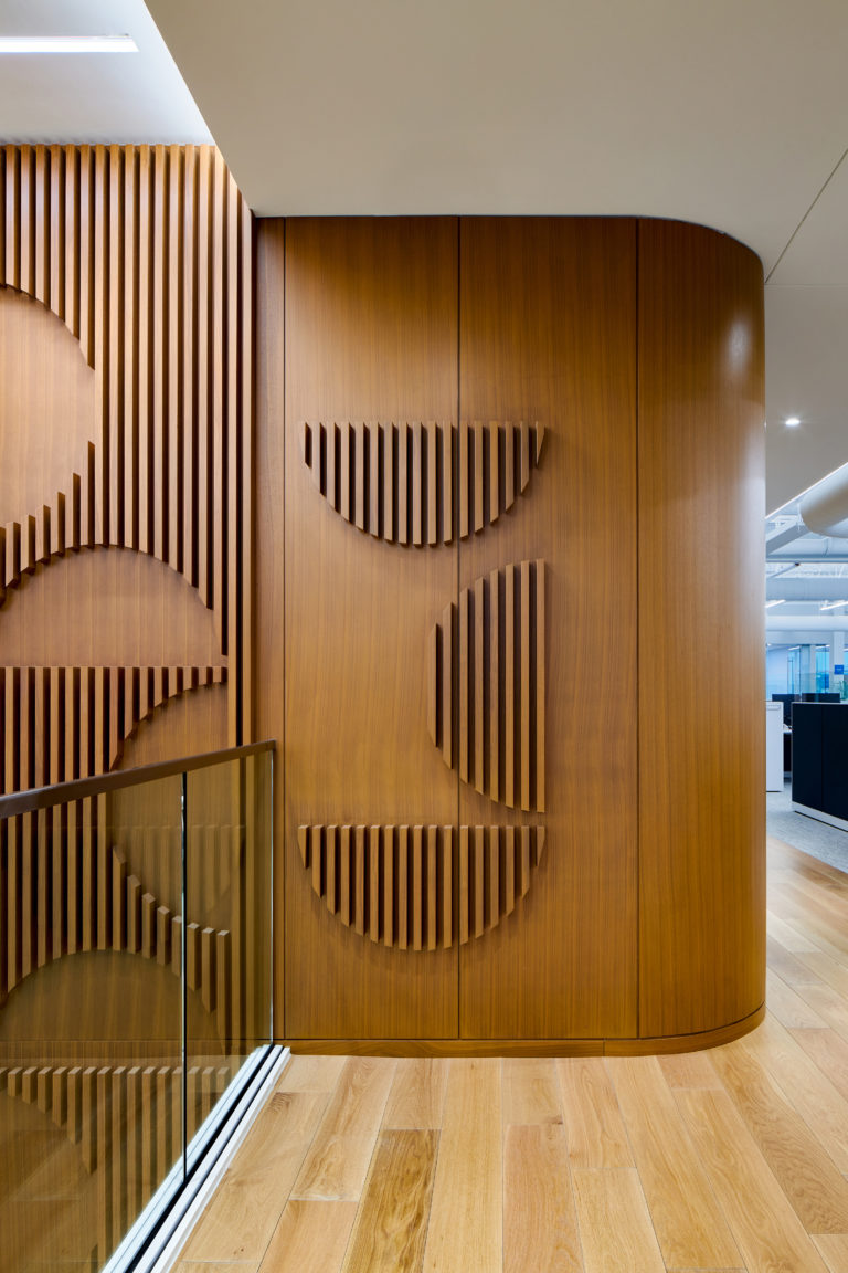 Elements from the Scoular logo are created using raised wood slats along the walls of the office.