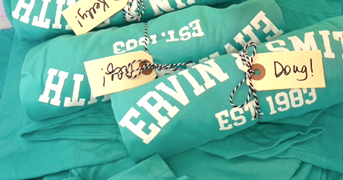 Ervin and Smith t-shirts rolled up with employee name tags tied around