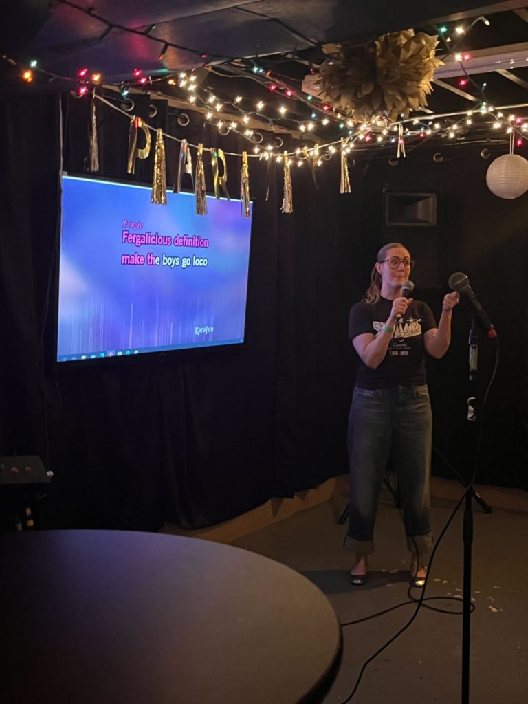 a woman singing karaoke in a bar
