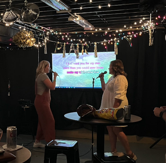 Two women singing karaoke