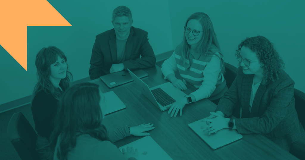 A photo of five E&S employees sitting around a conference table is show with a teal overlay.