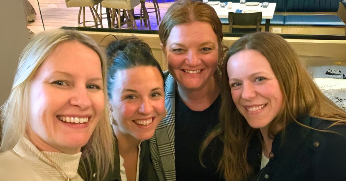 E&S executive leadership— Leanne, Katie, Ashley and Brittany—pose for a selfie in a restaurant.