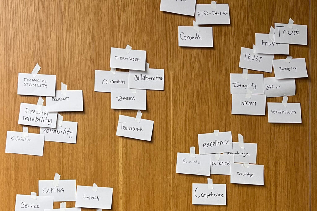 Sticky notes arranged on a wooden door during a group brainstorm session.