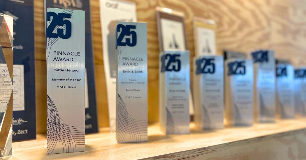 Pinnacle awards lined up on a shelf.