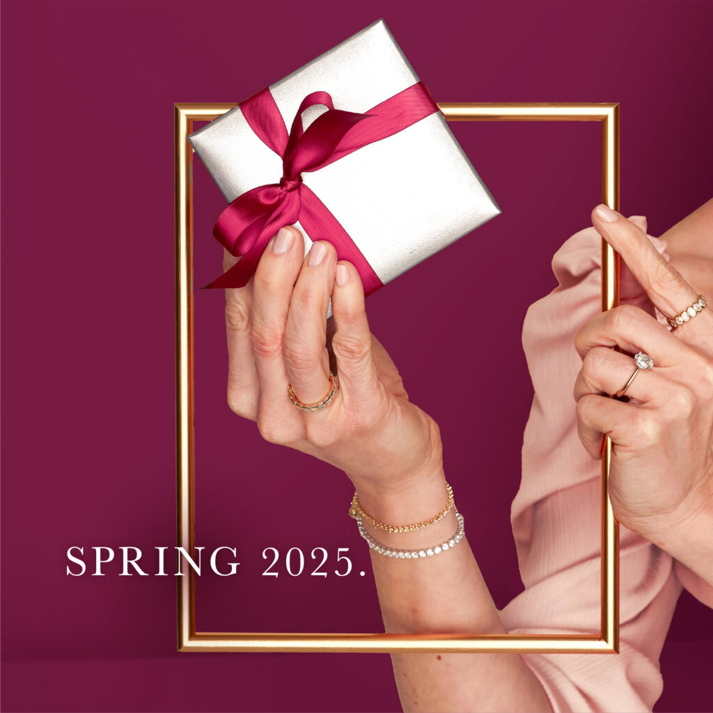 Hands of a model holding a gold frame in one hand and a Borsheims silver gift box with a burgundy bow in the other. The text "Spring 2025" is overlayed in white.