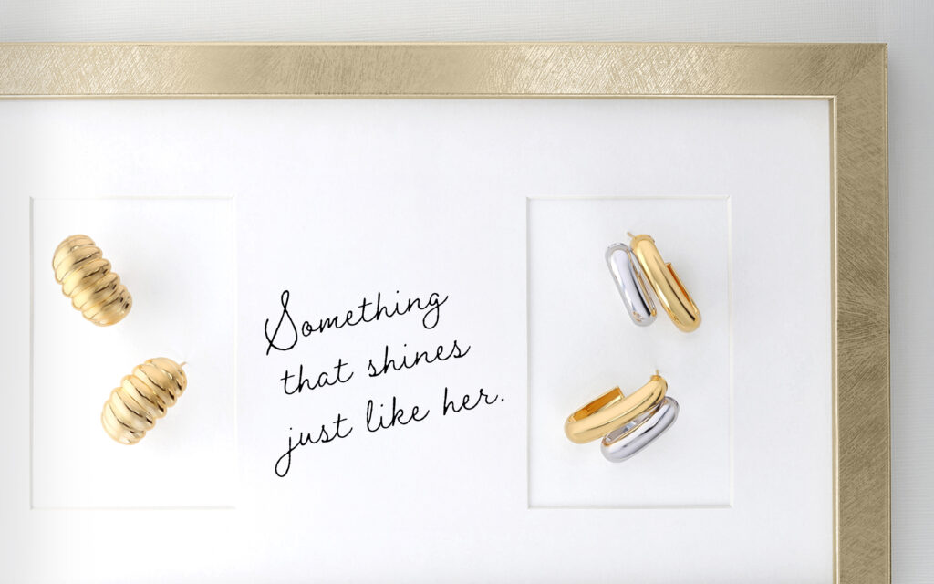 Small gold hoop earrings surrounded by a gold picture frame and a handwritten note that says "Something that shines just like her."